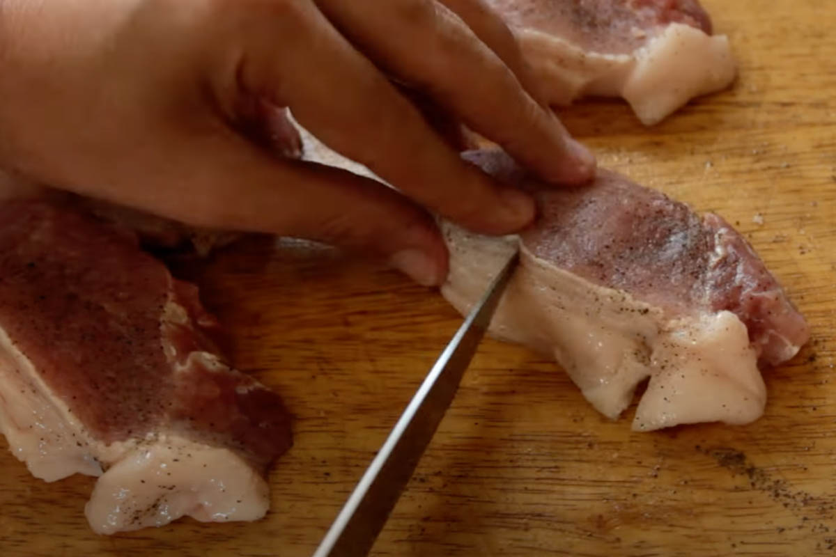 Slicing the fat of the pork chop