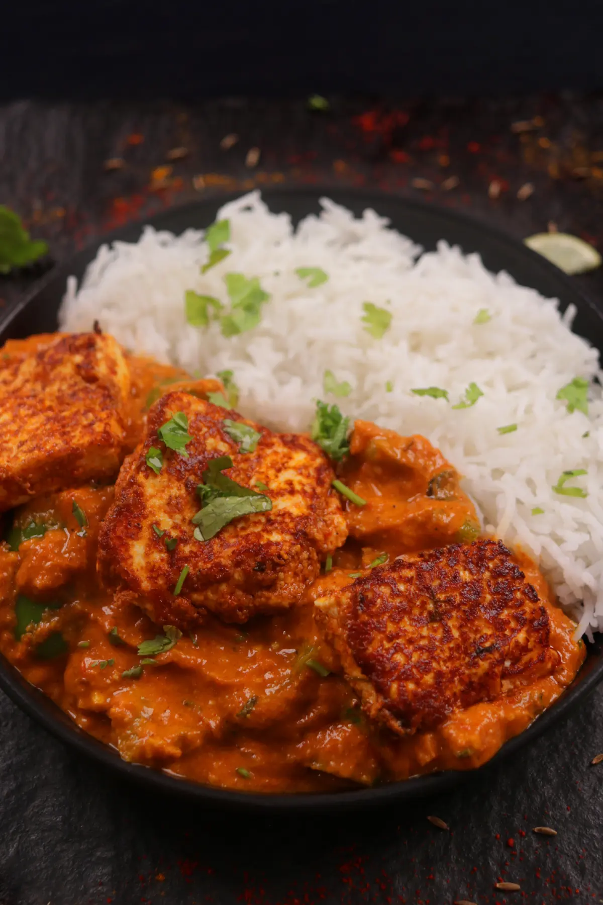 Paneer tikka masala with rice and cilantro.